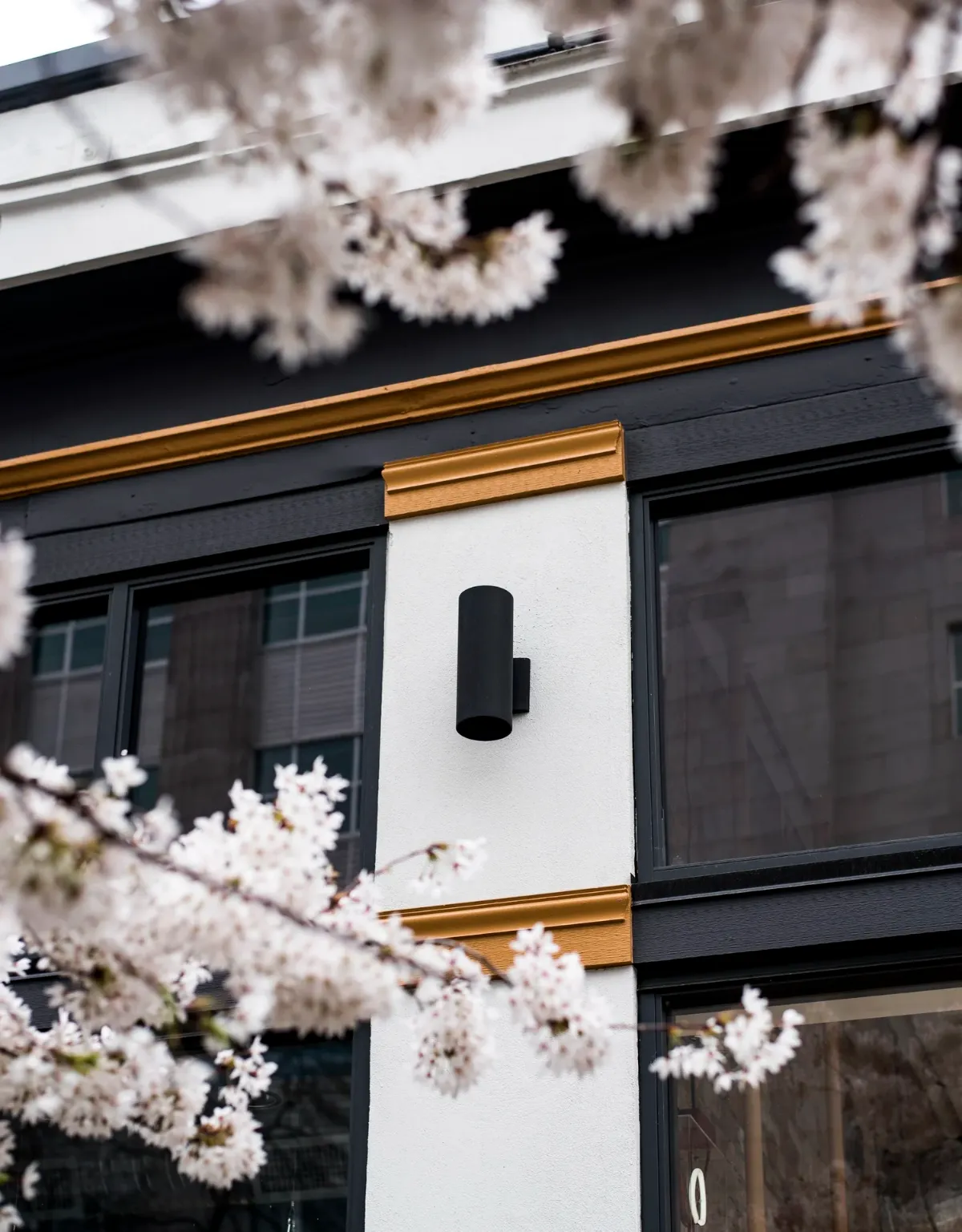 The restored facade in cherry blossom, gold trim against black and white