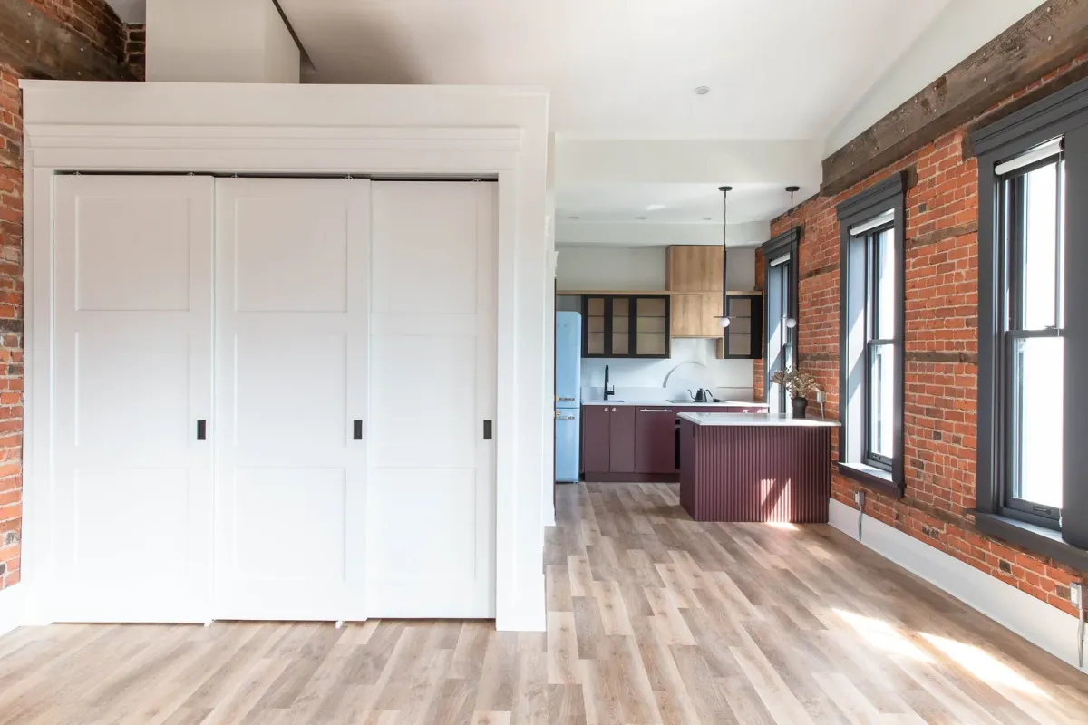 Living space opening onto the kitchen, brick and black-framed windows