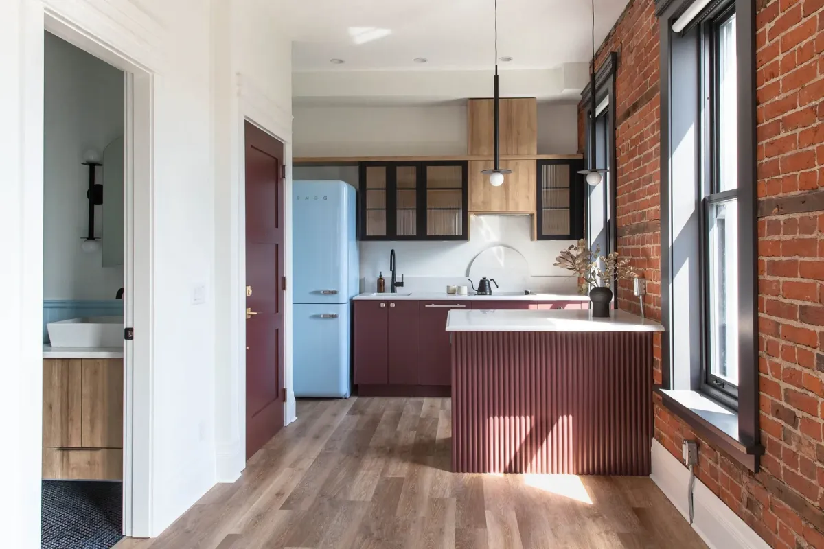 The kitchen island under its pendants, the retro fridge beside it
