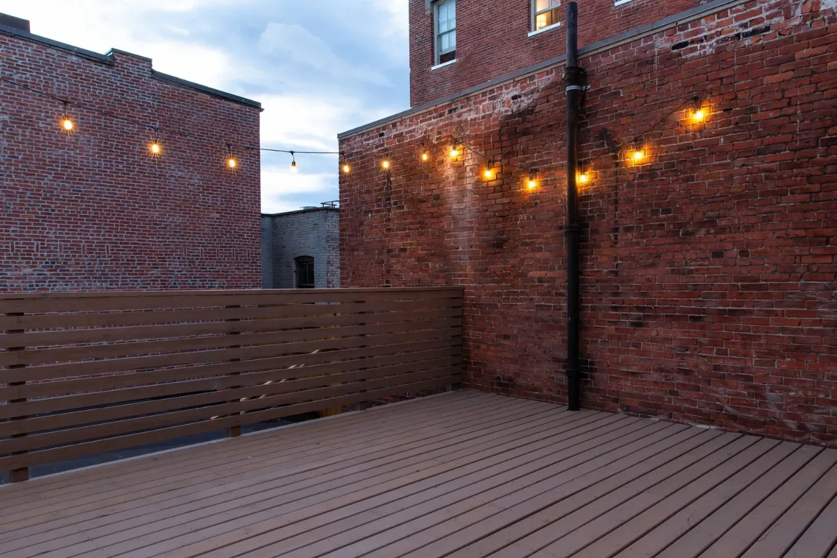 The rooftop deck at dusk, the city behind it