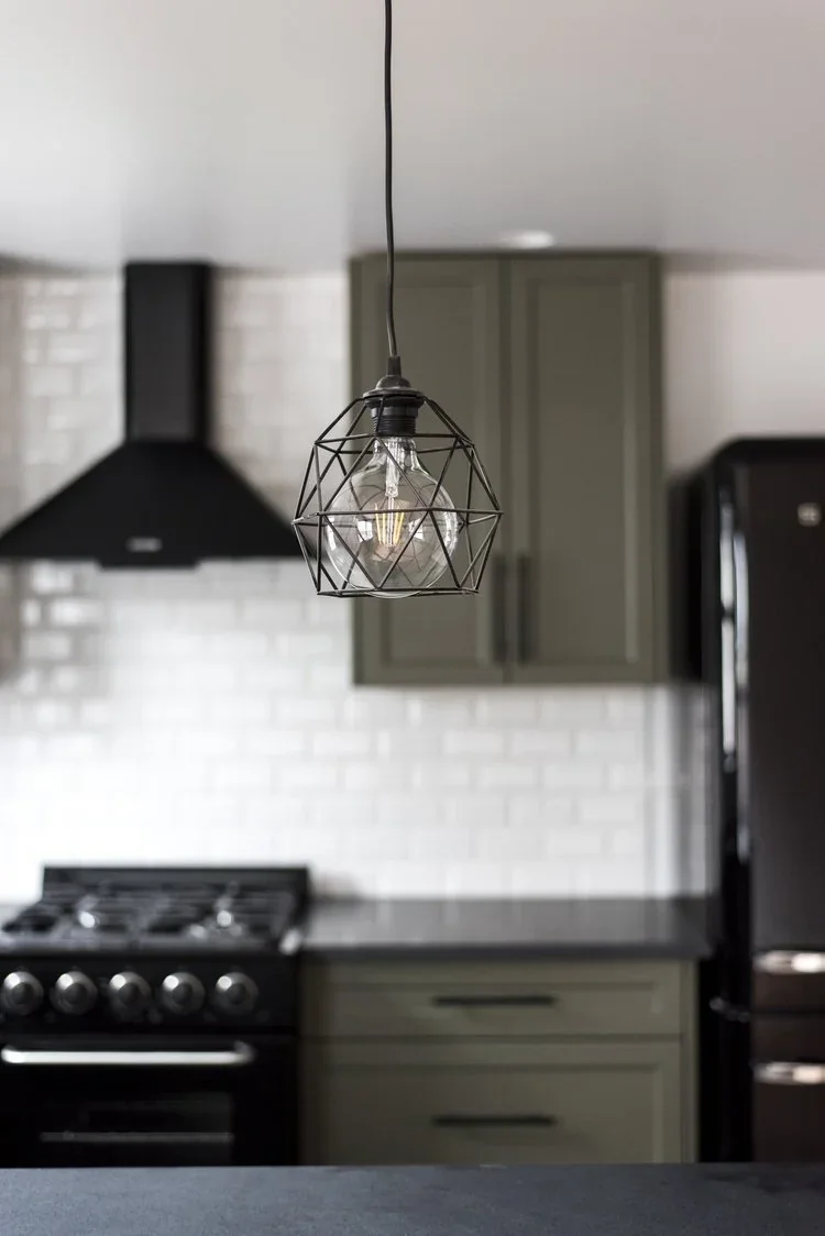 Kitchen on the Kennedy floor, olive cabinetry under a pendant light