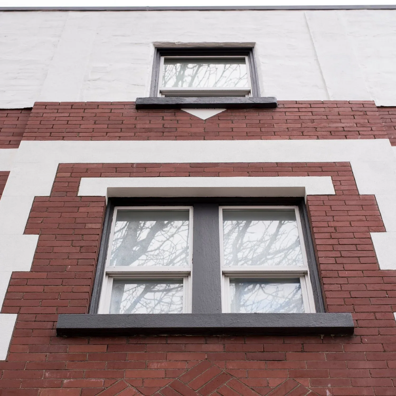 A third-storey window in the brick facade, seen from the street