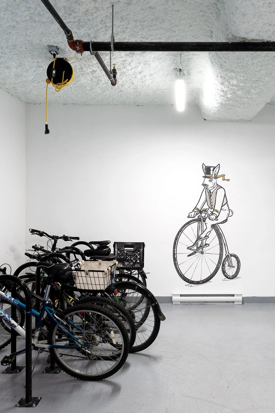 The bike storage room, with a mural of a sea otter on a penny-farthing