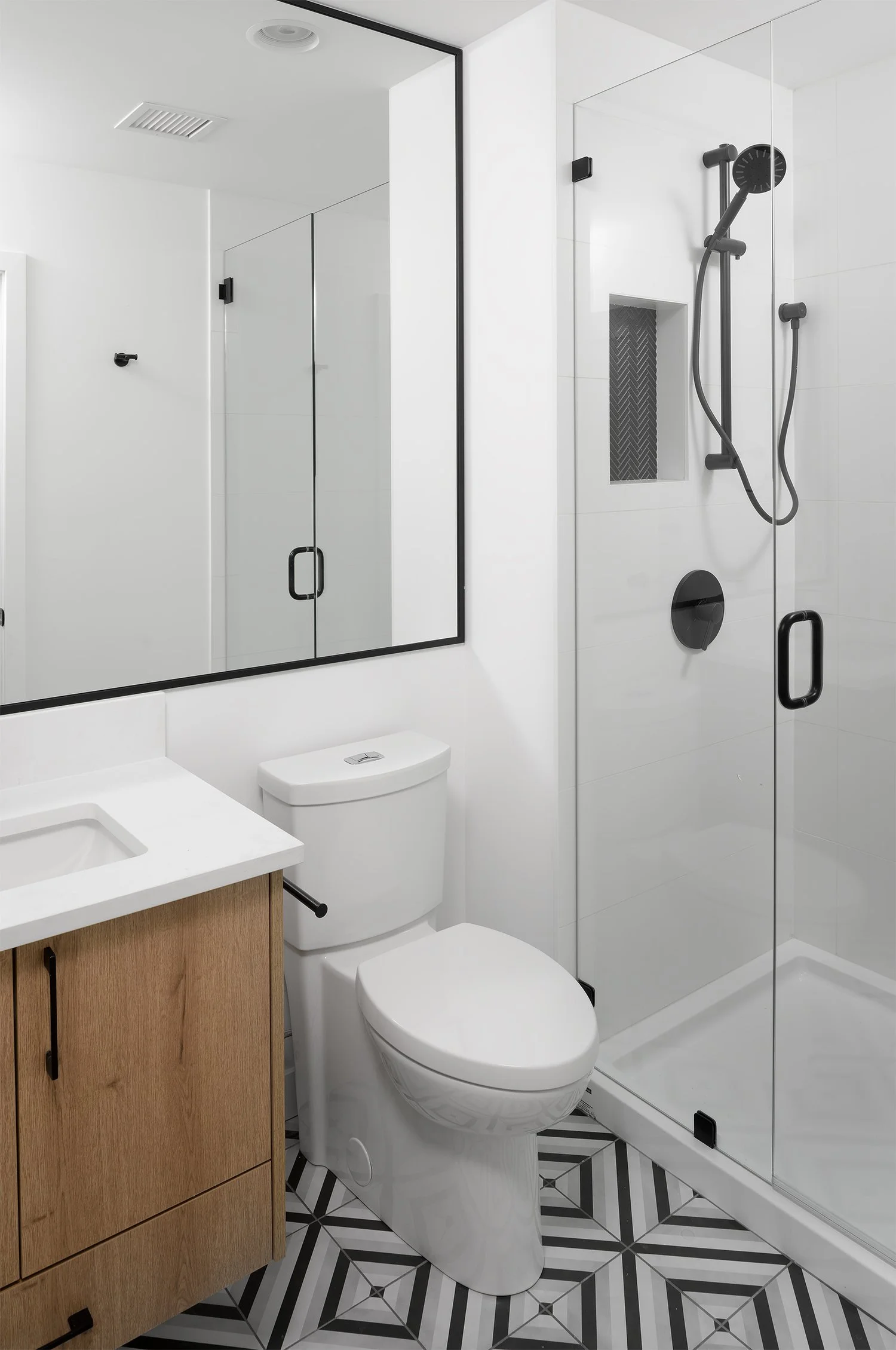 Walk-in glass shower over a patterned tile floor