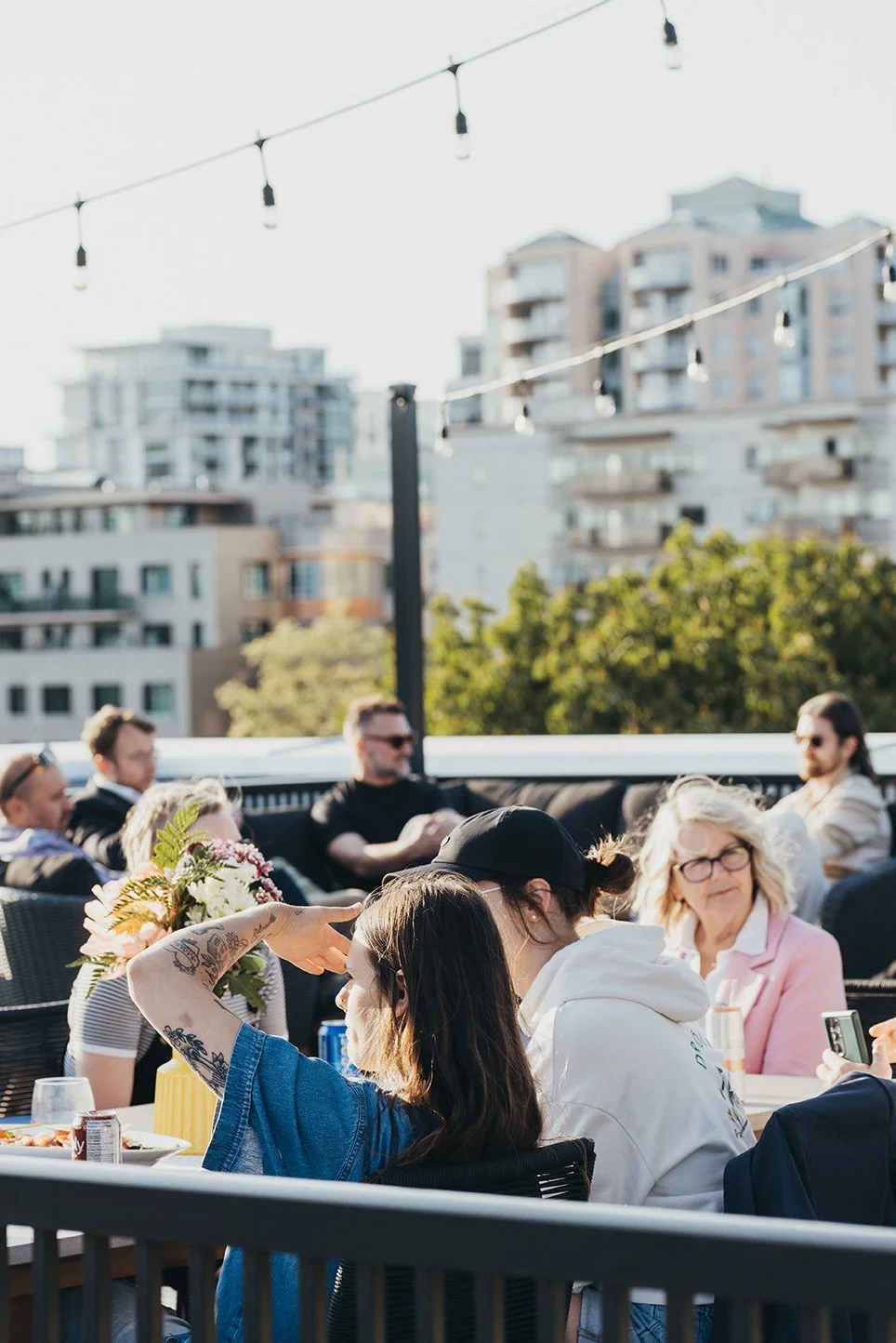 The rooftop terrace under string lights, with residents at the table