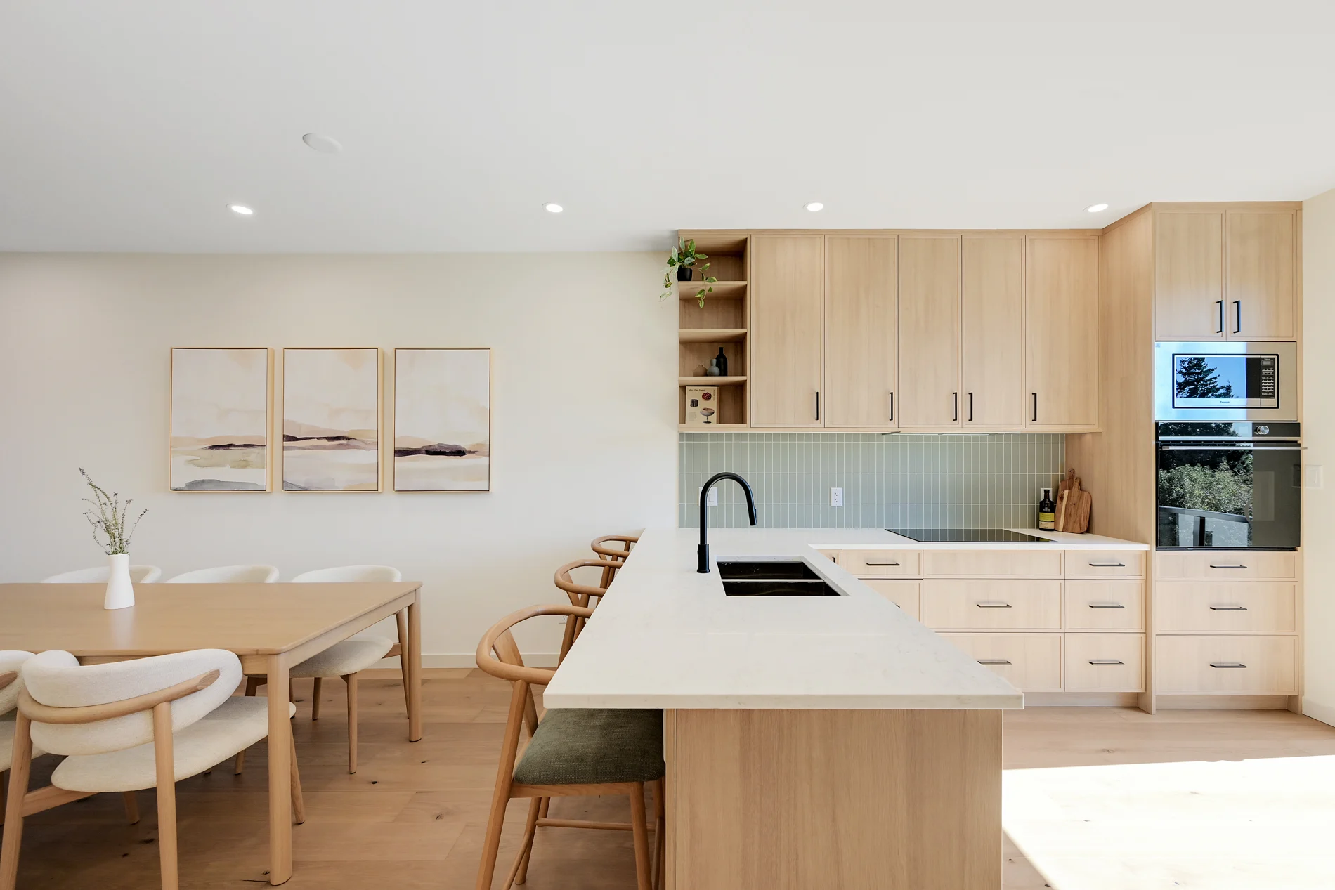 The kitchen island and oak cabinetry, seen from the dining table