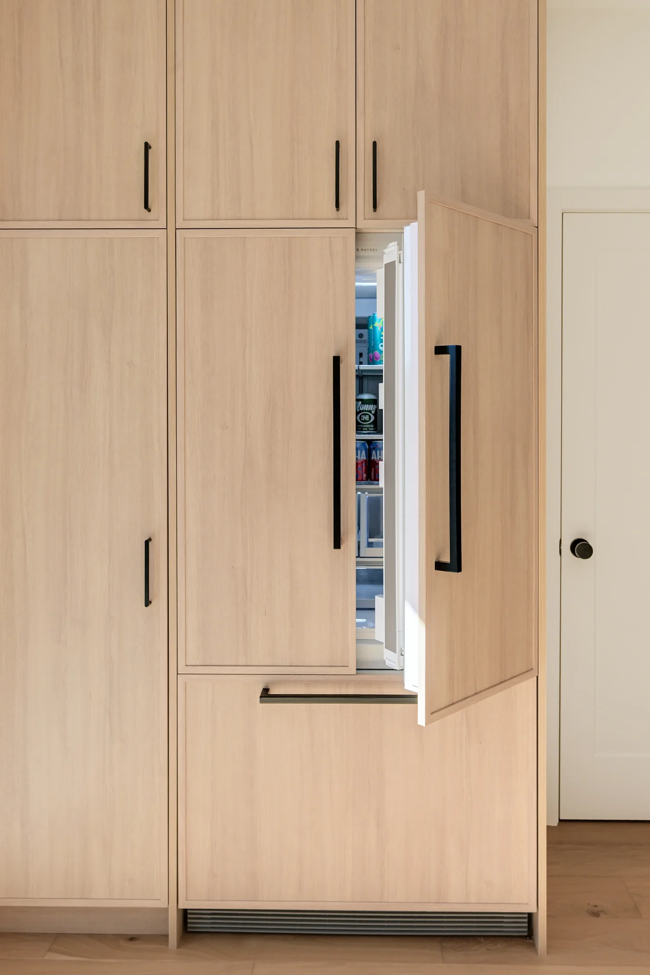 The refrigerator integrated behind oak panelling