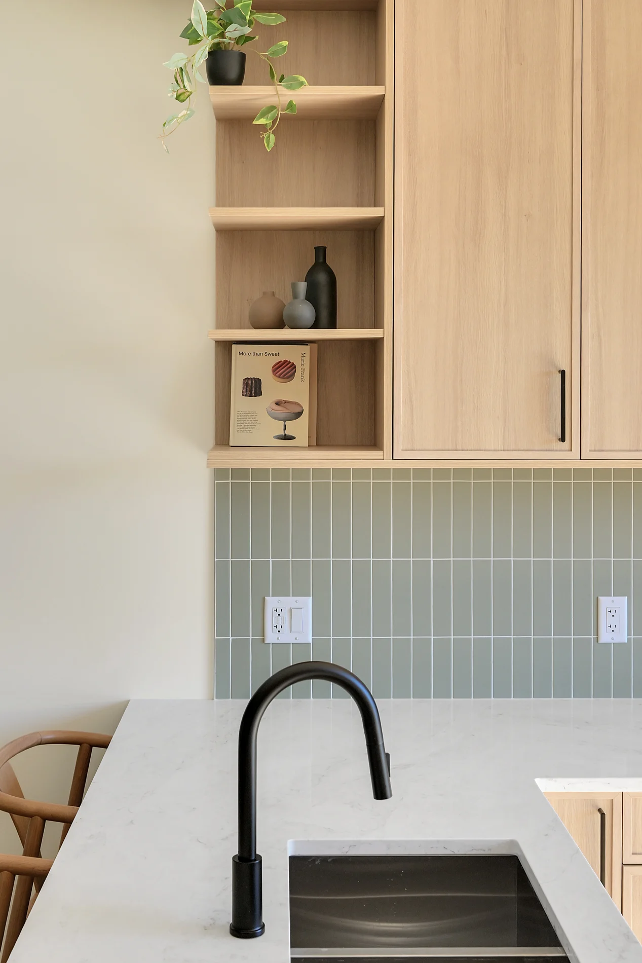 The sink, tiled backsplash and integrated lighting under the oak uppers