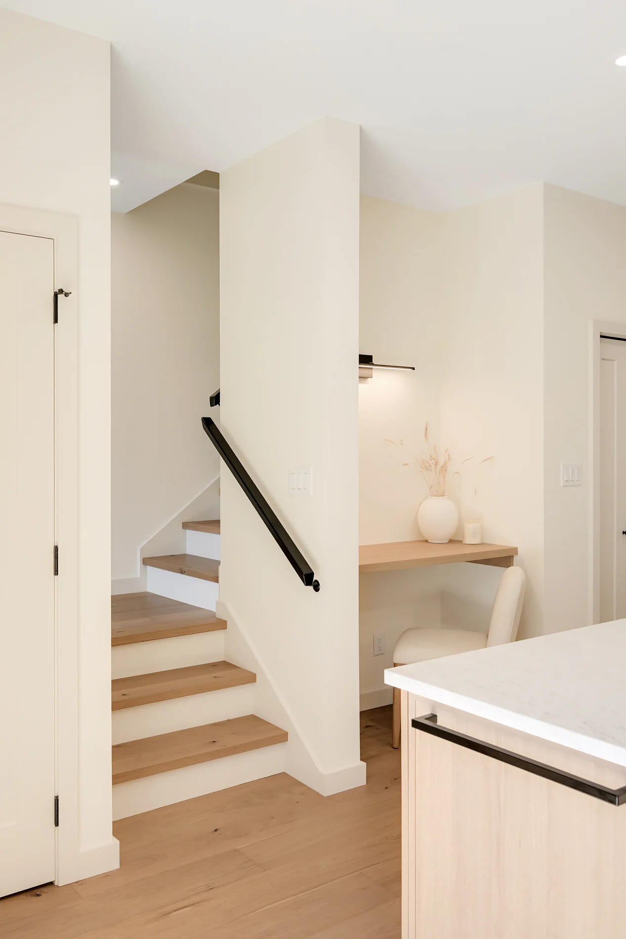 The stair and its black handrail, off the kitchen