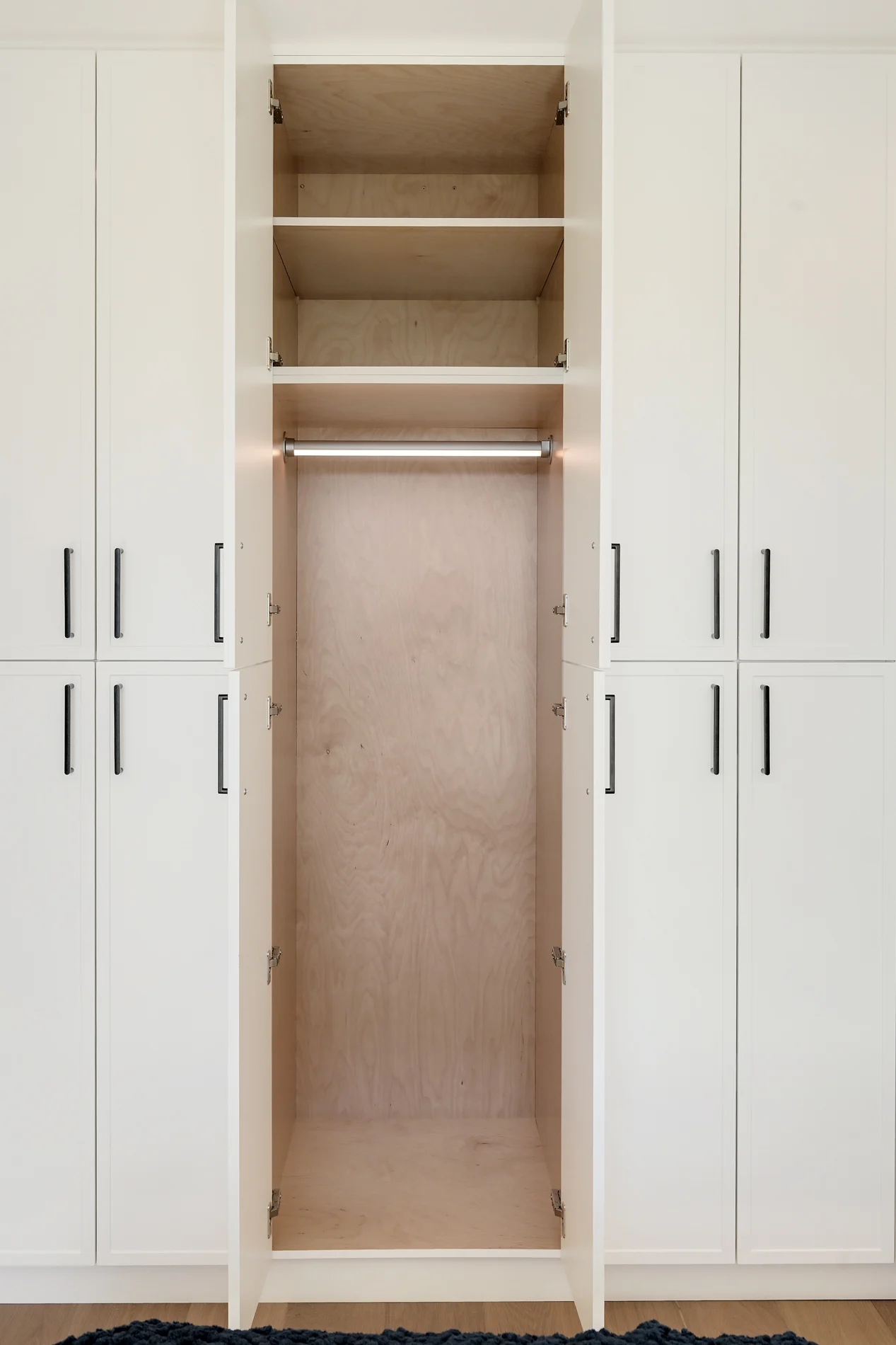 A wardrobe opened to its oak interior