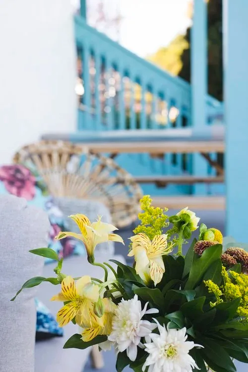 Yellow and white flowers on a table by the water